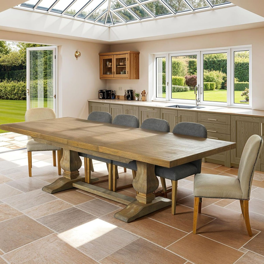 Dining area with wooden table and chairs in a well-lit kitchen with large windows.